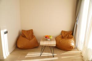 een kamer met 2 oranje stoelen en een tafel met een fruitschaal bij RUMI Hotel in Batoemi