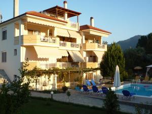 a hotel with a swimming pool and a building at Villa Thassos Paradise in Limenas
