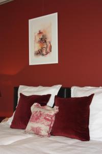 a bedroom with red walls and a bed with red pillows at B&B Hooglandhoeve in Geel