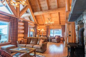 a living room with a couch and a fireplace at Revelstoke House Luxury Log House at Base of Resort in Revelstoke