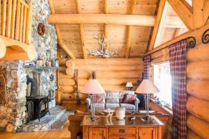 a living room with a fireplace in a log cabin at Revelstoke House Luxury Log House at Base of Resort in Revelstoke