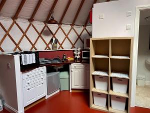 a kitchen with a desk and shelves in a room at The Yurts at Burnt House Farm in Newport