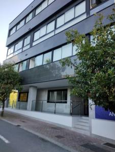 un edificio de oficinas en una calle con un árbol en Apartamento en Sada con piscina, en Sada