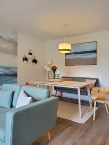 ein Wohnzimmer mit einem blauen Sofa und einem Tisch in der Unterkunft NordseeLiebe - Zeit Für Meer in Bredstedt