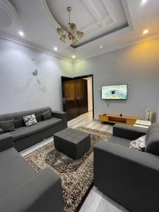 a living room with couches and a flat screen tv at غرفتين نوم ومجلس في أبها in Abha