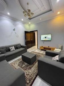a living room with couches and a flat screen tv at غرفتين نوم ومجلس في ابها بالقرب من Lavanda Park in Abha