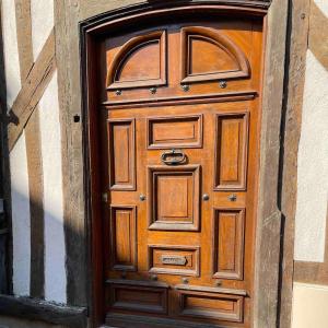 een houten deur op een gebouw met een archigunigunigunigunigunigunigun bij Hôtel particulier Champenois in Châlons-en-Champagne