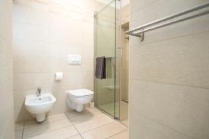 a bathroom with a toilet and a glass shower at Apartments E & E Piran in Piran