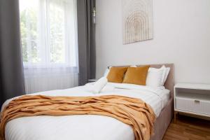 a bedroom with a large bed with a blanket on it at Cztery Czaple in Chełm