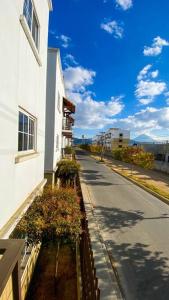 an empty street next to a white building at Paseo de la Arboleda apartamento in Quetzaltenango