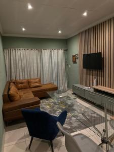 a living room with a glass table and a couch at Silverton Private Apartment in Pretoria