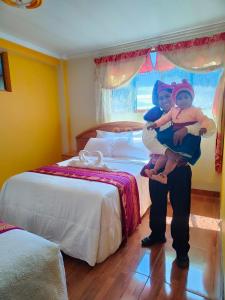 a man holding two children in a bedroom at Taquile Inti Raymi Lodge in Huillanopampa
