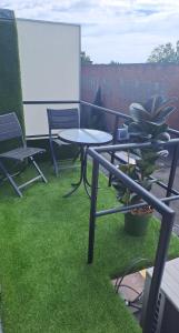 d'une terrasse avec une table, des chaises et de la pelouse. dans l'établissement BeautyD RED ROOM centrum Gullegem, à Wevelgem