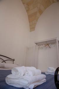 a room with a pile of towels on a bed at Casa Sole in Lecce +18 photos