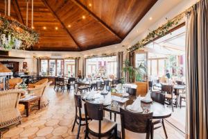 un restaurant avec des plafonds en bois, des tables et des chaises dans l'établissement Appartementhotel Seeblick, à Gronau