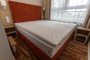 a large bed in a room with a window at Bel Mare Aqua Resort B&M in Międzyzdroje