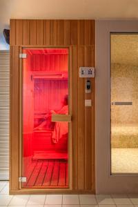 una habitación con una puerta de cristal con una persona dentro en BeautyD RED ROOM centrum Gullegem en Wevelgem