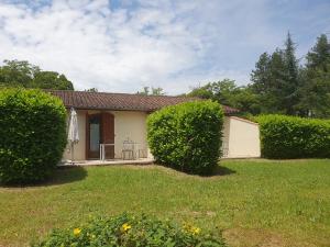 a house with two hedges in front of a yard at The Gare Gondrin in Gondrin