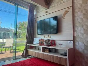 uma sala de estar com uma televisão de ecrã plano na parede em Family Comfort, Casa residencial Aconchegante em Foz do Iguaçu