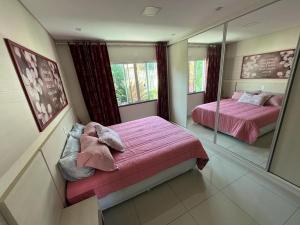 een slaapkamer met 2 bedden en een spiegel bij Family Comfort, Casa residencial Aconchegante in Foz do Iguaçu