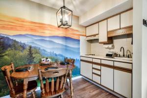 a kitchen with a table with a mountain mural on the wall at Bear Pause Retreat/Steps to Pkwy/With Indoor Pool in Gatlinburg