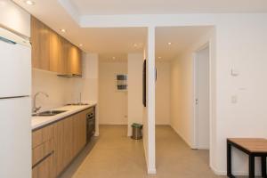 a kitchen with wooden cabinets and a table in it at Austral Departamentos in Ushuaia