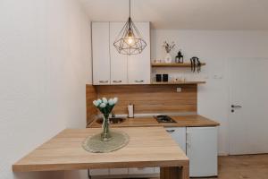 a kitchen with a wooden table with a vase of flowers at Stan na dan Flora Nevesinje in Nevesinje