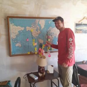 um homem parado em frente a um mapa do mundo em HOSTEL la Casa del Patio BB em Bahía Blanca