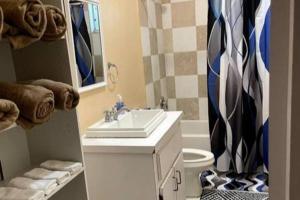 ein Badezimmer mit einem Waschbecken, einem WC und einem Spiegel in der Unterkunft Paradise Haven in Nassau