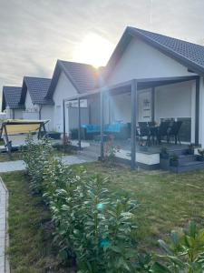 a house with a patio with a table and chairs at Villa LIPI - Home Away from Home in Balatonszemes