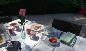 un tavolo con cibo e un fiore sopra di chambre dans maison avec piscine et cuisine a Saint-Étienne