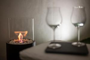 una candela in un contenitore di vetro con un bicchiere di vino di Asmara exclusive "Loft industrial" a Brindisi