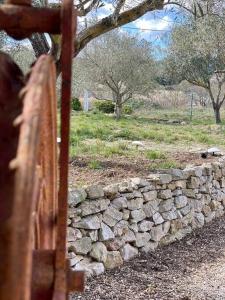 a stone wall next to a stone fence at Gite Thym spa au coeur d'une oliveraie des Corbières in Saint-Jean-de-Barrou