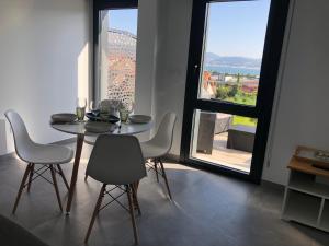 d'une salle à manger avec une table, des chaises et une fenêtre. dans l'établissement Os amorodos, à Pontevedra