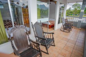 a room with rocking chairs on a porch at Hotel Sierra Arenal in Fortuna