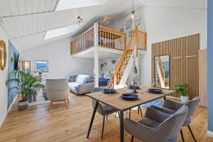 a living room with a table and chairs and a staircase at cruwzo I Maisonette - Netflix - Parking - near Audi in Ingolstadt