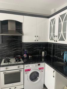 a kitchen with a stove and a washing machine at Mersin condominium Life City with pool and sea in Erdemli