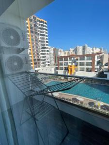 a glass balcony with a swimming pool on a building at Mersin condominium Life City with pool and sea in Erdemli