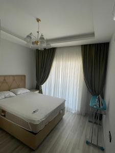a bedroom with a large bed and a window at Mersin condominium Life City with pool and sea in Erdemli