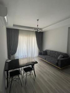 ein Wohnzimmer mit einem Sofa und einem Tisch in der Unterkunft Mersin condominium Life City with pool and sea in Erdemli