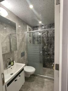 ein Bad mit einer Dusche, einem WC und einem Waschbecken in der Unterkunft Mersin condominium Life City with pool and sea in Erdemli