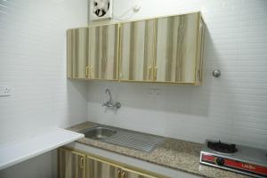 サラーラにあるRED-7 - Alwadi Salalahの木製のキャビネットとシンクを備えたキッチン +45枚の写真