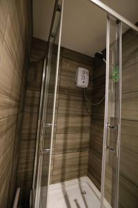 a shower with a glass door in a bathroom at Pristine Relocation 3 beds Apartment in London