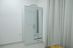a white cabinet with a mirror in a room at RED Alwadi Salalah in Salalah +45 photos