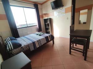 a bedroom with a bed and a desk and a window at RESIDENCIAL 14 DE DICIEMBRE in Santa Cruz de la Sierra