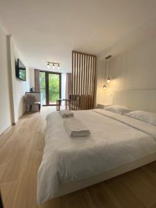 a bedroom with a large white bed and a desk at ECO PARK RESORT in Ijevan