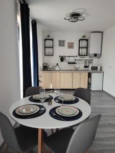 ein Esszimmer mit einem Tisch und Stühlen sowie eine Küche in der Unterkunft Paradis Baile Felix in Baile Felix