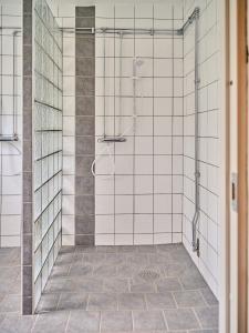 a bathroom with a shower with white tiled walls at Herrestad Bed & Guestroom in Värnamo