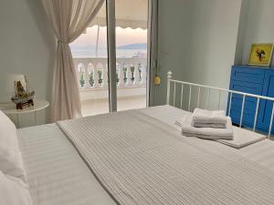 サランダにあるAmarilis Luxury Apartmentsの海の見えるベッドのある寝室