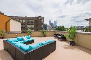 a rooftop patio with a couch and chairs on a roof at Loft640 in Center City w Parking, Pool, Gym in Philadelphia